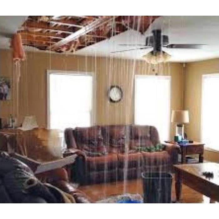 water leaking from ceiling into room filled with furniture